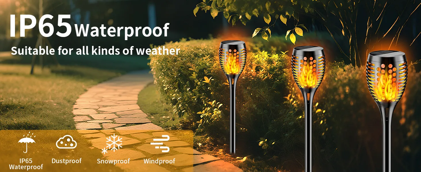Decorative solar torch lights with flickering flame effect illuminating a garden pathway at dusk.
