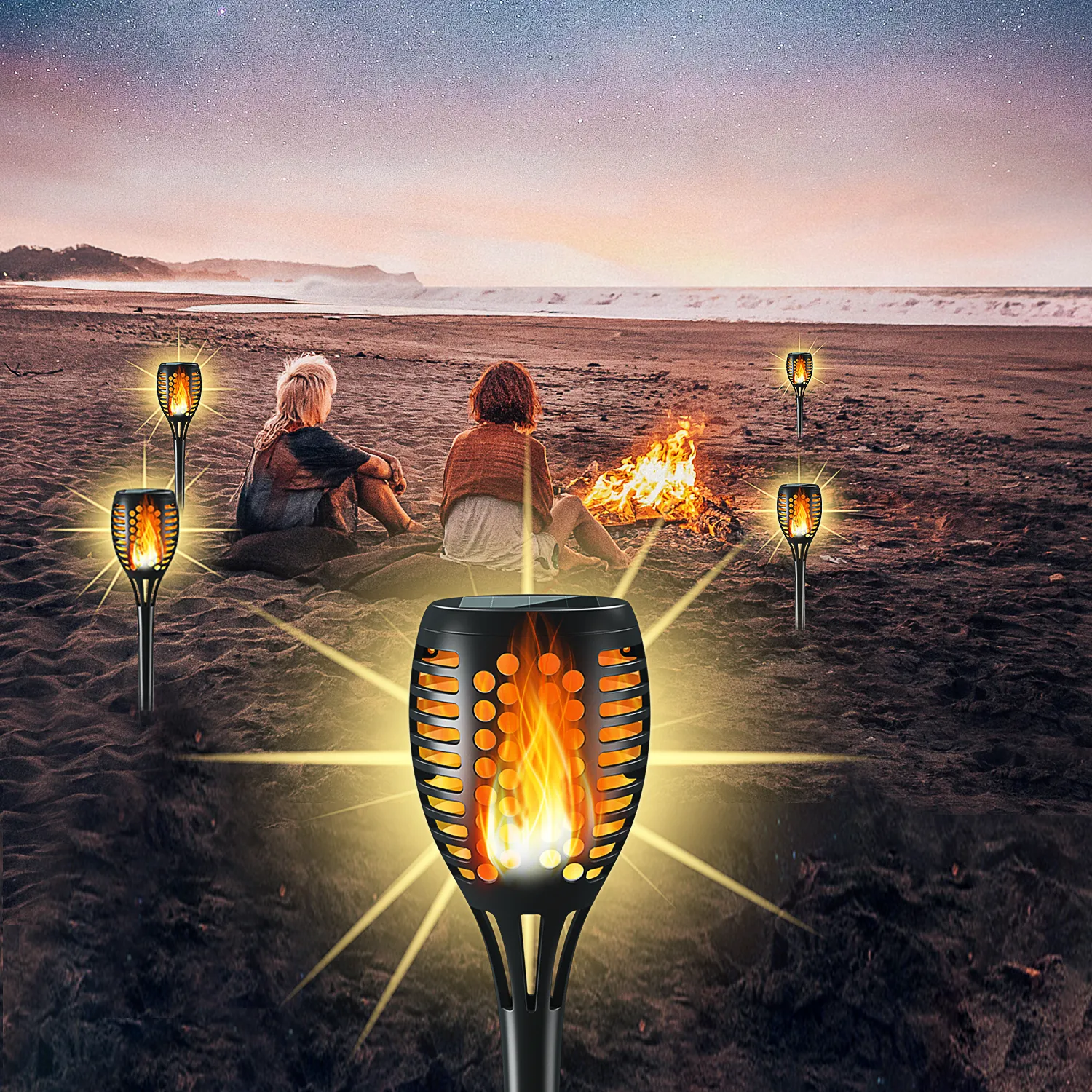 Round hollow solar torch lights laid on seaside beach for camping party, soft warm flickering flame.